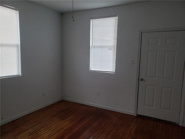 spare room featuring dark wood-type flooring