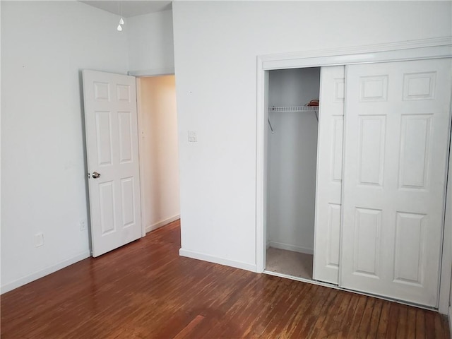 unfurnished bedroom featuring a closet and dark hardwood / wood-style floors