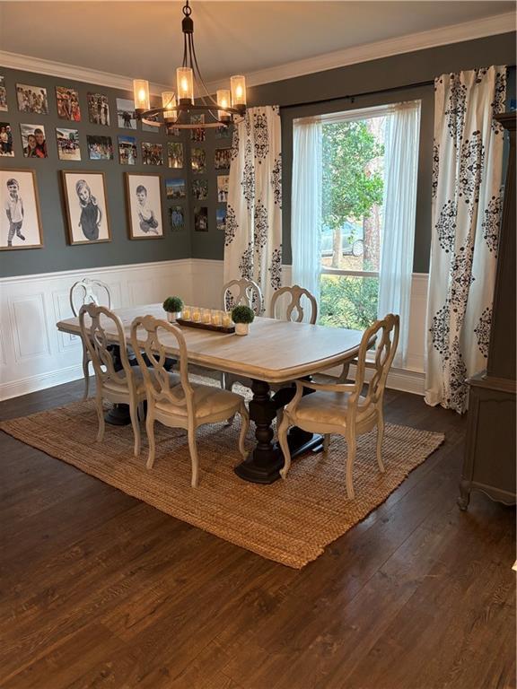 dining room featuring a notable chandelier, dark hardwood / wood-style floors, and ornamental molding