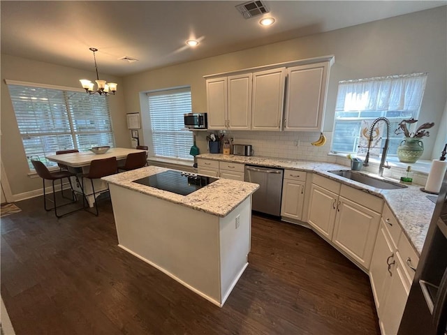 kitchen featuring pendant lighting, a center island, sink, and appliances with stainless steel finishes