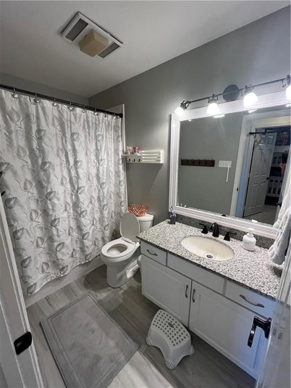 bathroom with curtained shower, vanity, and toilet