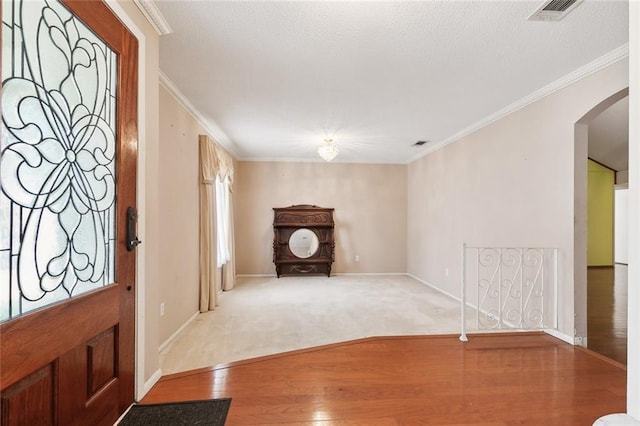 entryway with crown molding and hardwood / wood-style floors