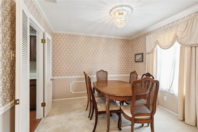 dining room featuring crown molding, light carpet, and a chandelier