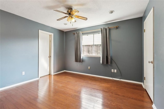 empty room with ceiling fan and wood-type flooring