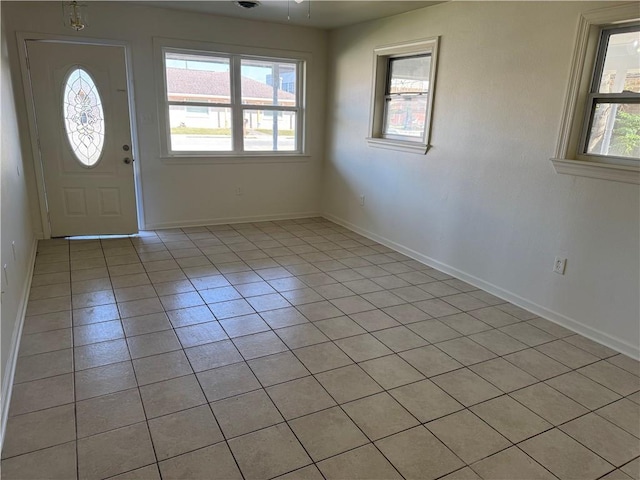 foyer entrance with ceiling fan and light tile patterned flooring