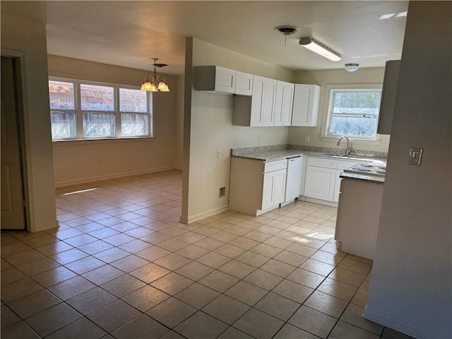 kitchen with white cabinets, light tile patterned floors, sink, and a chandelier