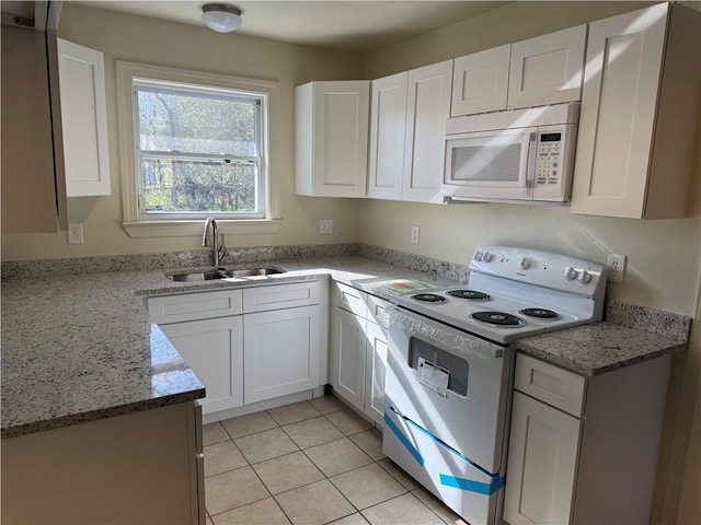 kitchen with light tile patterned floors, white appliances, white cabinetry, and sink