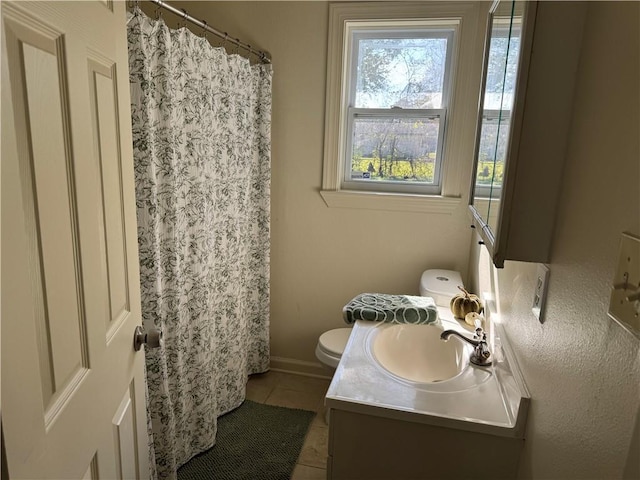 bathroom with toilet, vanity, and tile patterned floors