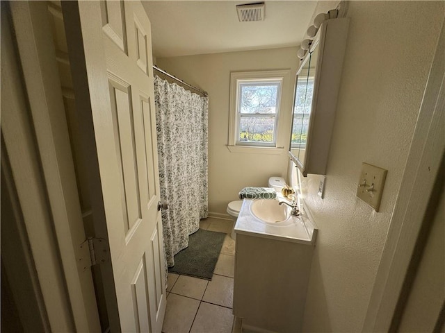 bathroom featuring tile patterned flooring, vanity, and toilet