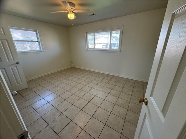 tiled empty room featuring plenty of natural light and ceiling fan