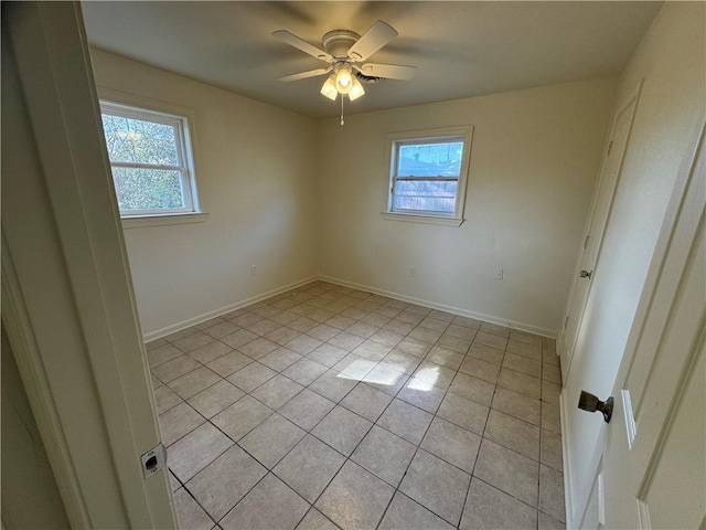 tiled spare room with ceiling fan and a healthy amount of sunlight