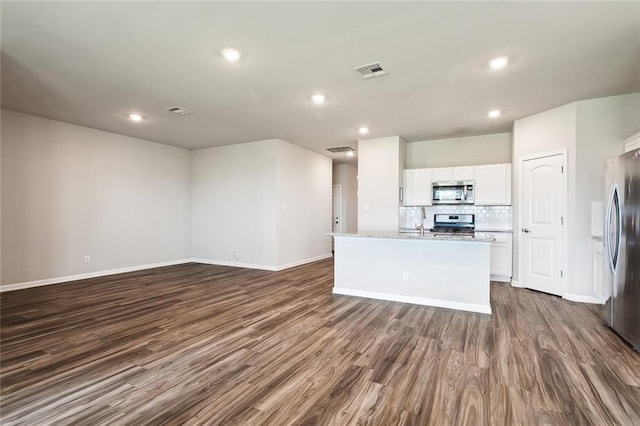 kitchen featuring white cabinetry, an island with sink, appliances with stainless steel finishes, and dark wood-type flooring