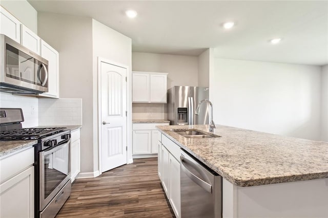 kitchen with white cabinets, sink, decorative backsplash, an island with sink, and appliances with stainless steel finishes