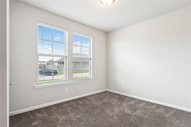 spare room with dark colored carpet