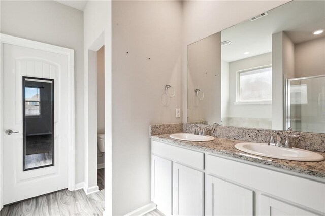 bathroom featuring walk in shower, vanity, and toilet