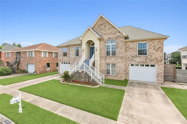 split foyer home featuring an attached garage, stairway, concrete driveway, and brick siding