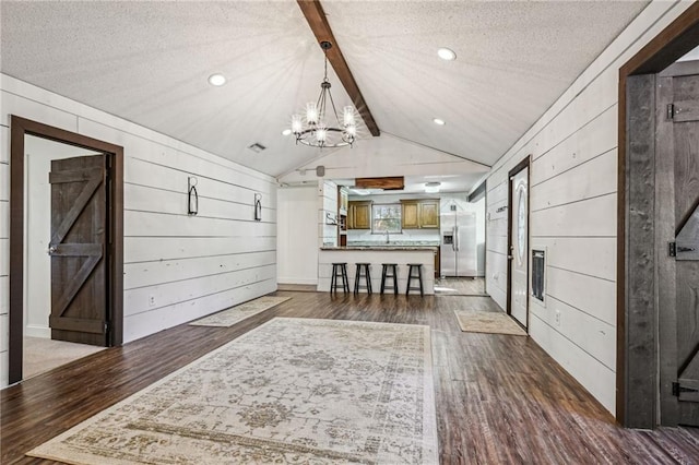 interior space featuring vaulted ceiling with beams, a textured ceiling, dark hardwood / wood-style flooring, and wooden walls