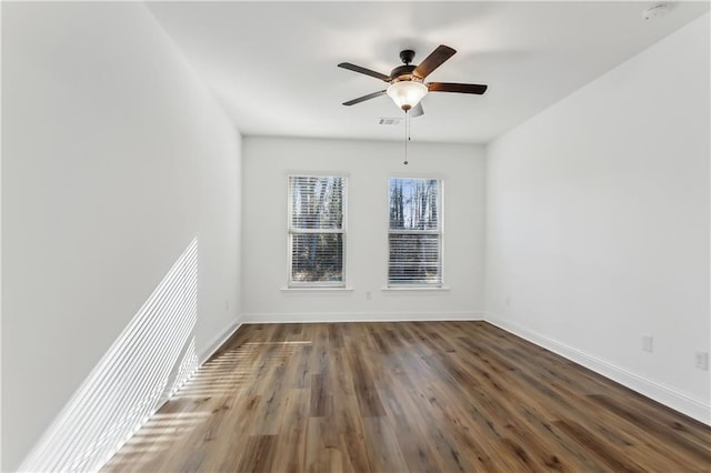 spare room with ceiling fan and dark wood-type flooring