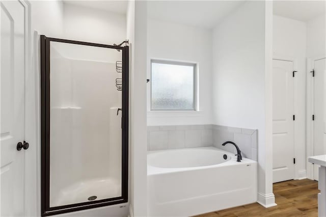 bathroom featuring hardwood / wood-style floors and independent shower and bath