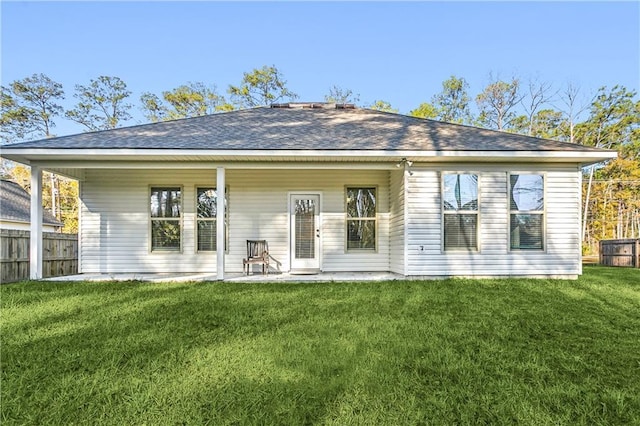 back of house with a patio and a lawn