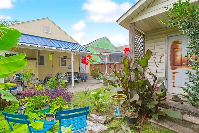 view of yard featuring ceiling fan and a patio