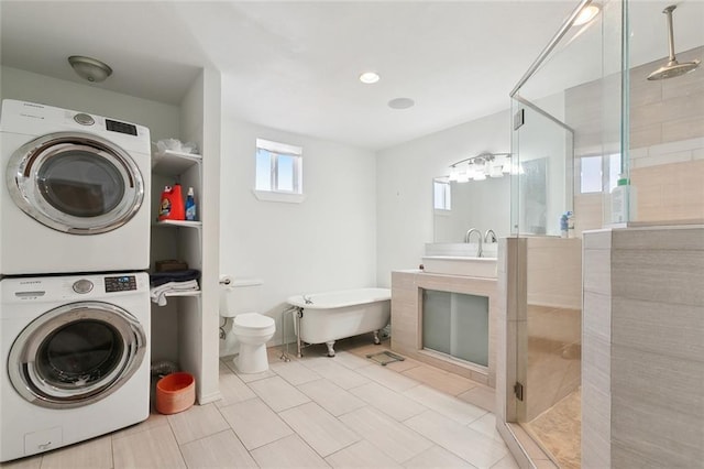 full bathroom with plus walk in shower, tile patterned floors, stacked washer and dryer, toilet, and vanity