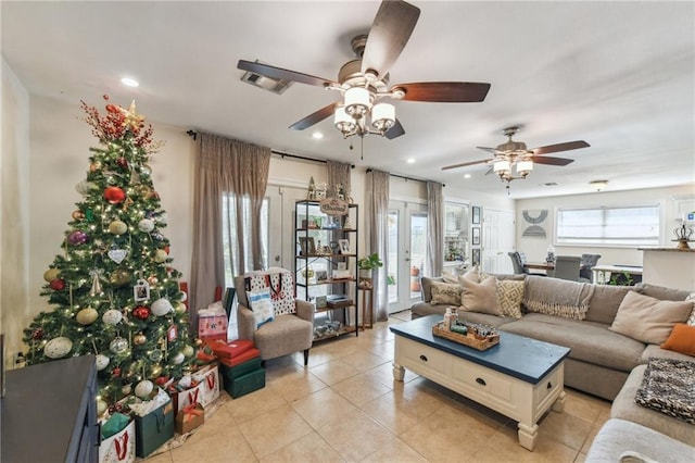 tiled living room with ceiling fan, a wealth of natural light, and french doors