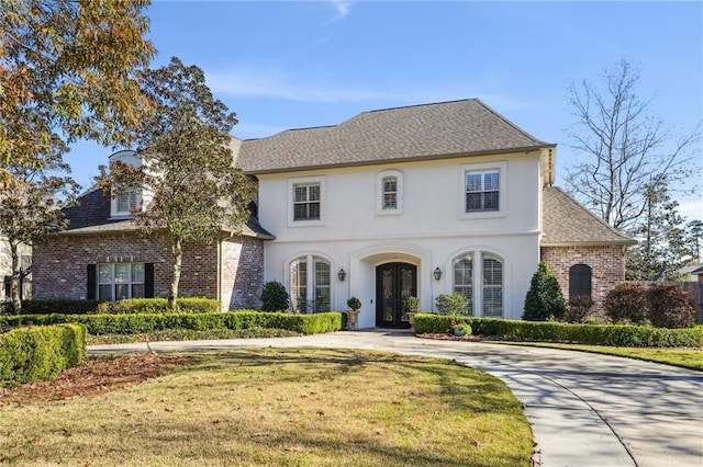 view of front facade with a front yard and french doors