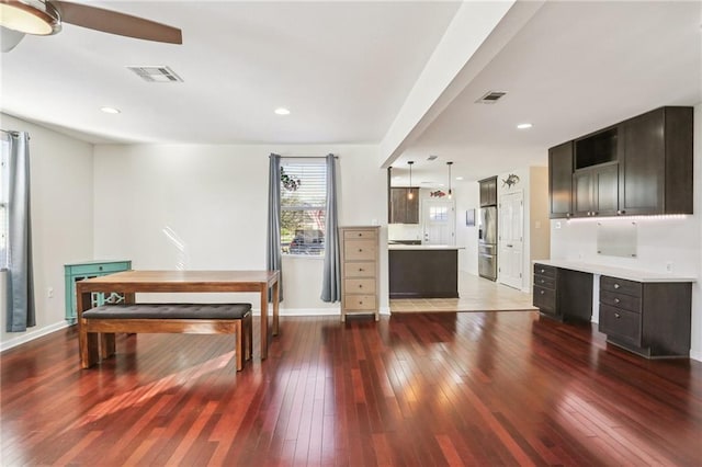 dining room with ceiling fan and dark wood-type flooring