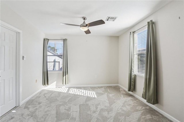 carpeted spare room with ceiling fan and a healthy amount of sunlight