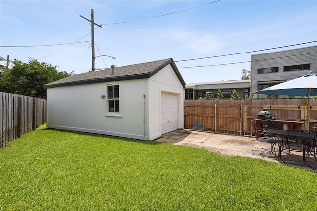 rear view of house with a lawn, a garage, a patio area, and an outdoor structure