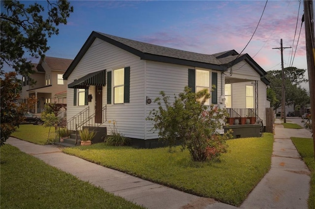 property exterior at dusk with a lawn