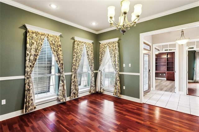 unfurnished room with light hardwood / wood-style flooring, plenty of natural light, crown molding, and a notable chandelier