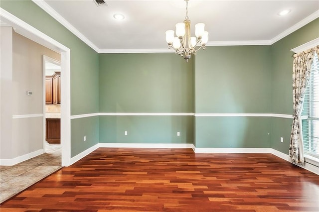 spare room with dark hardwood / wood-style floors, crown molding, and a notable chandelier