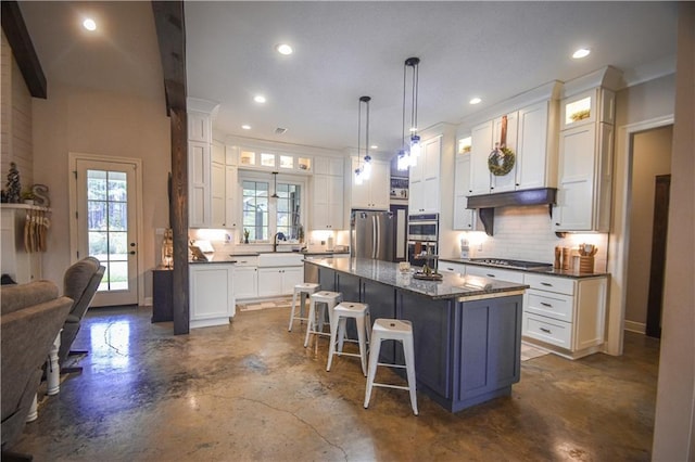 kitchen with white cabinets, a breakfast bar, a kitchen island, and stainless steel appliances