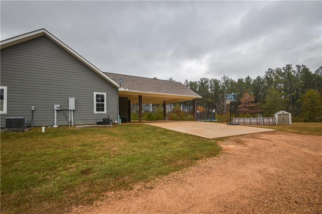 exterior space featuring a shed, a trampoline, a patio, and central air condition unit