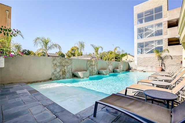 view of swimming pool featuring a patio, fence, and a fenced in pool