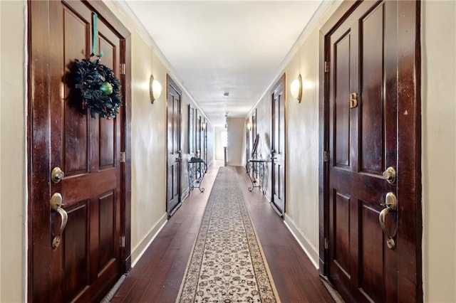 corridor with dark hardwood / wood-style floors and crown molding