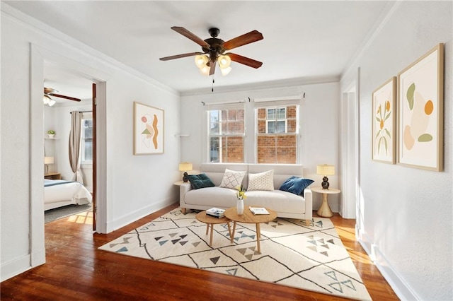 living area featuring ceiling fan, hardwood / wood-style floors, and ornamental molding