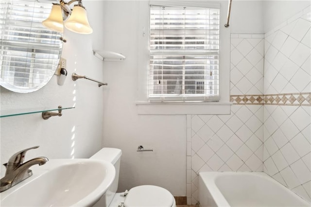 bathroom with toilet, sink, and a wealth of natural light