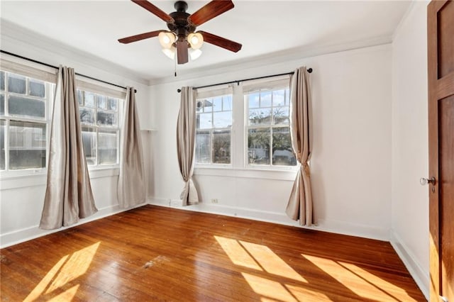 empty room featuring hardwood / wood-style flooring, ceiling fan, and crown molding