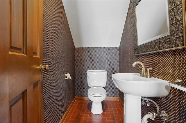 bathroom featuring toilet and lofted ceiling