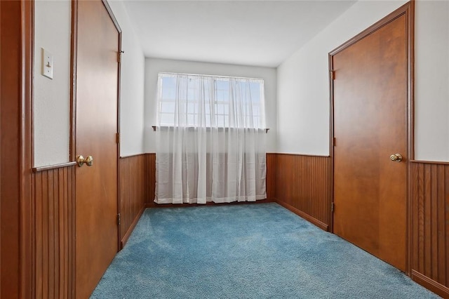 carpeted bedroom with wooden walls