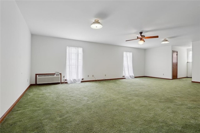 carpeted empty room featuring a wall mounted air conditioner and ceiling fan