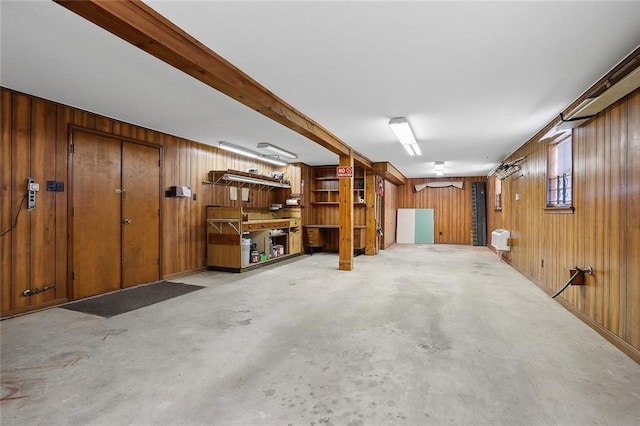 basement with a workshop area and wooden walls