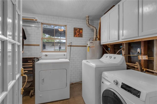 washroom with cabinets, separate washer and dryer, tile walls, and water heater