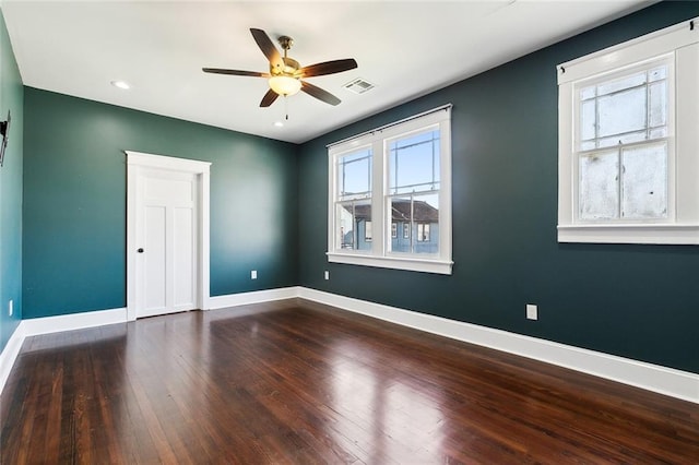 empty room with ceiling fan and dark wood-type flooring