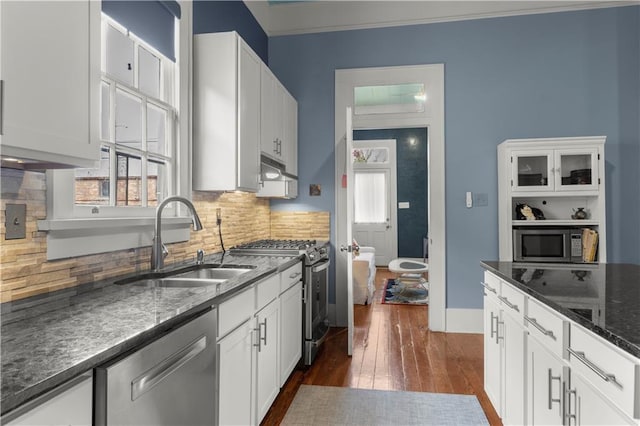 kitchen featuring dark stone countertops, sink, stainless steel appliances, and white cabinets