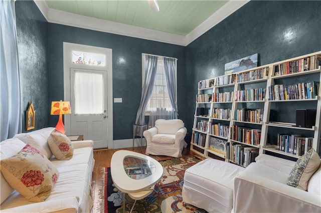 sitting room with a healthy amount of sunlight, wood-type flooring, and ornamental molding