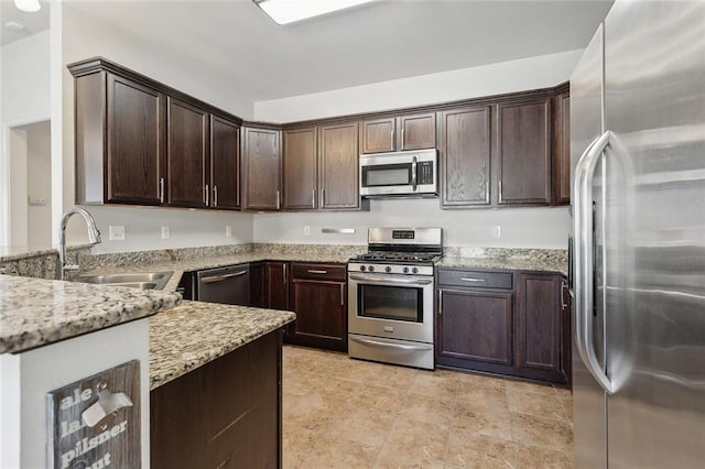 kitchen featuring dark brown cabinetry, light stone countertops, sink, and stainless steel appliances